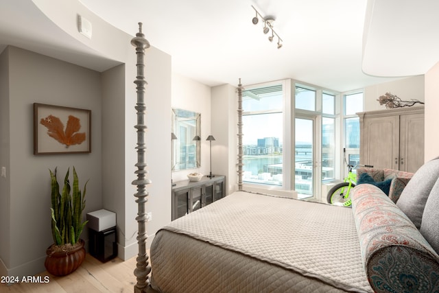 bedroom featuring a wall of windows and light wood-type flooring