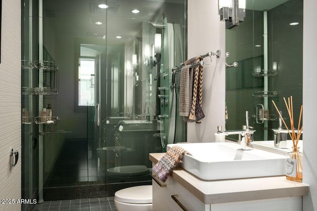 bathroom featuring tile patterned flooring, vanity, a shower with door, and toilet