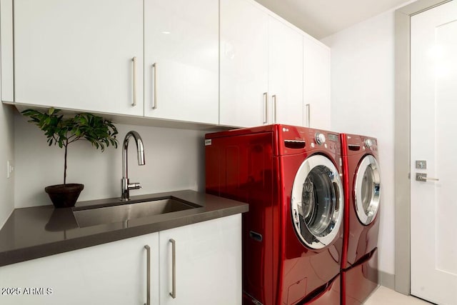 laundry room with sink, washing machine and dryer, and cabinets