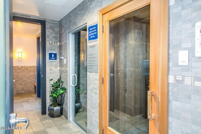 bathroom with tile walls and tile patterned floors