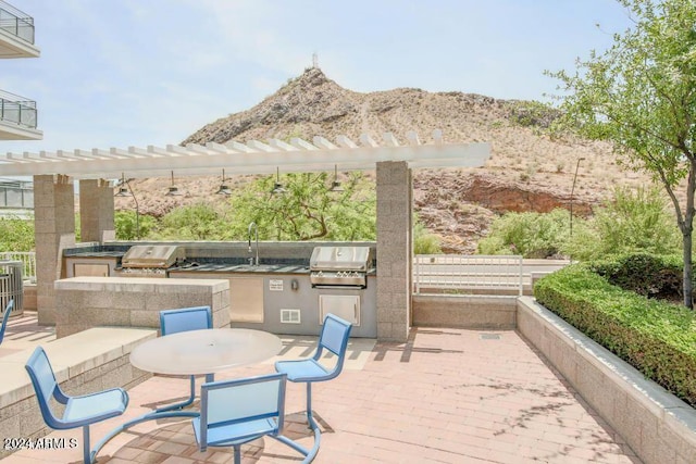 view of patio / terrace with area for grilling, a grill, and a mountain view