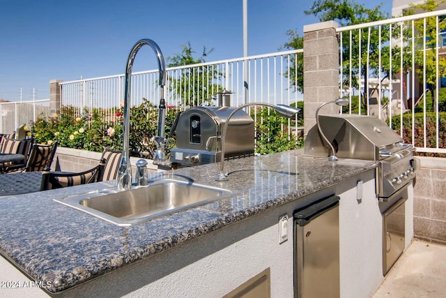 view of patio with an outdoor kitchen, sink, and grilling area