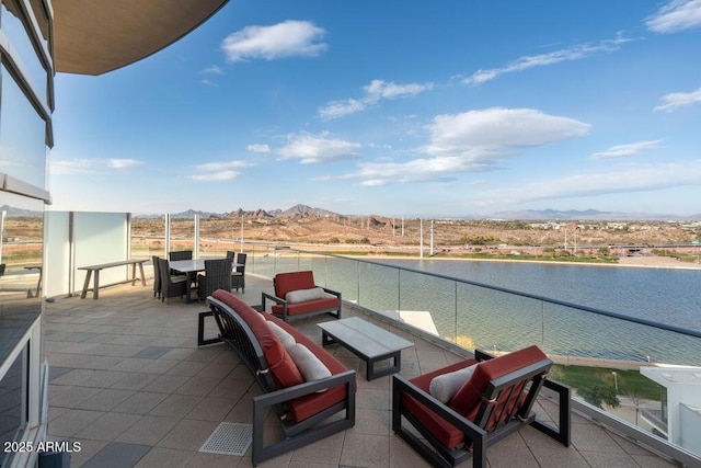 view of patio with a water and mountain view and a balcony