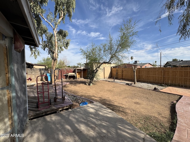 fenced backyard with a storage unit, a patio, and an outbuilding
