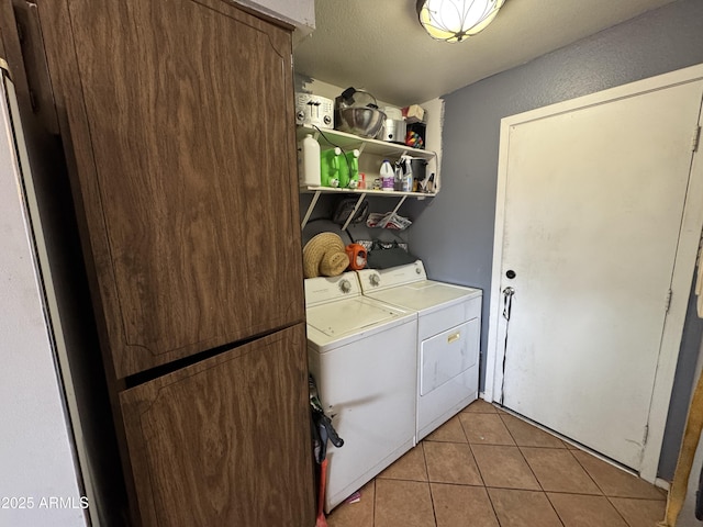 laundry room featuring washing machine and clothes dryer and light tile patterned floors