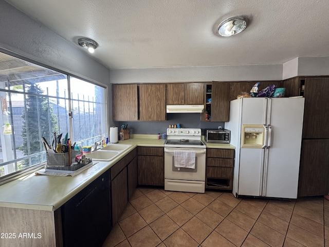 kitchen with white appliances, under cabinet range hood, a sink, light countertops, and a textured ceiling
