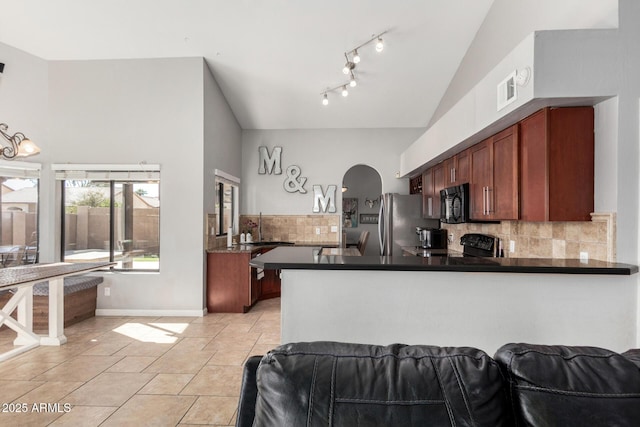 kitchen featuring a peninsula, dark countertops, tasteful backsplash, and black appliances