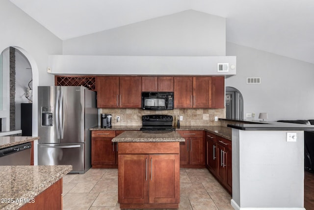 kitchen featuring visible vents, vaulted ceiling, dark stone counters, black appliances, and tasteful backsplash