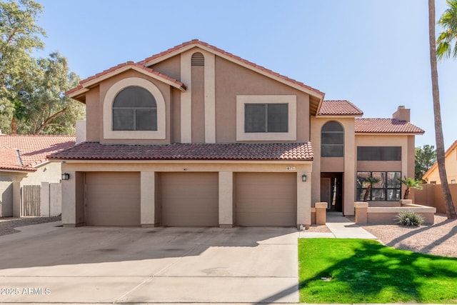 view of front facade featuring an attached garage, driveway, a tiled roof, and stucco siding