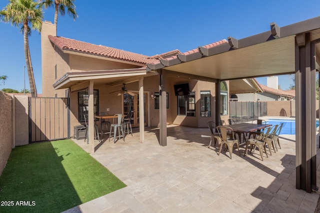 view of patio with a fenced backyard, a fenced in pool, outdoor dining area, and a ceiling fan