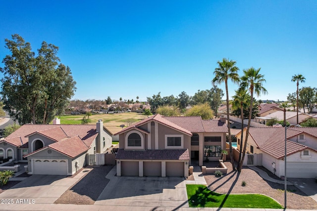 view of front of property with stucco siding, concrete driveway, a garage, a residential view, and a tiled roof