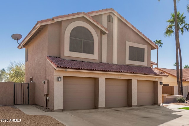 view of front of house featuring a garage, driveway, a tile roof, and stucco siding