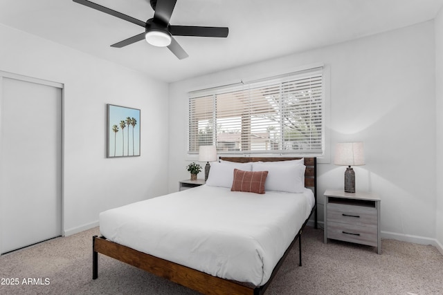 bedroom with light carpet, a closet, a ceiling fan, and baseboards