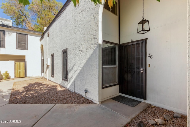 entrance to property featuring a patio area and stucco siding