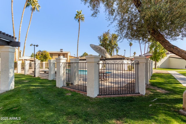 view of gate with a fenced in pool and a yard