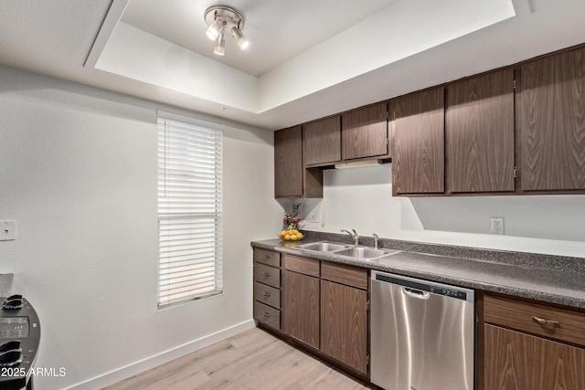 kitchen with dishwasher, sink, light hardwood / wood-style floors, a raised ceiling, and dark brown cabinets