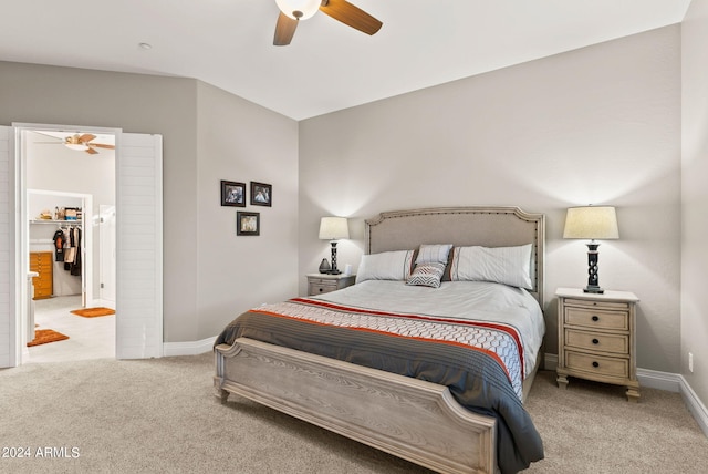 carpeted bedroom with ceiling fan, a closet, and a spacious closet