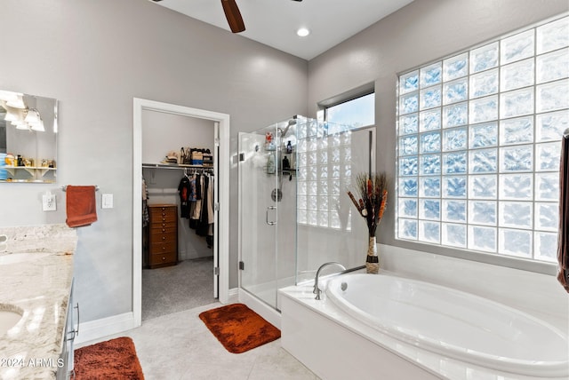 bathroom with plus walk in shower, vanity, ceiling fan, and tile patterned flooring