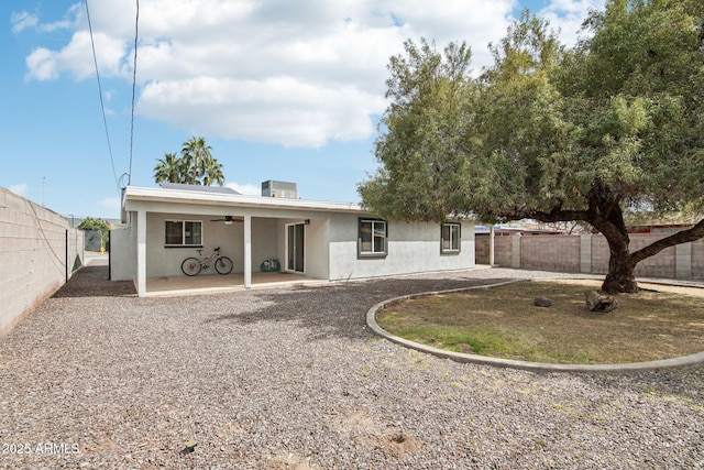 back of house with stucco siding, a fenced backyard, a patio, and a ceiling fan