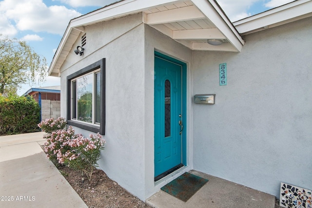 view of exterior entry featuring stucco siding