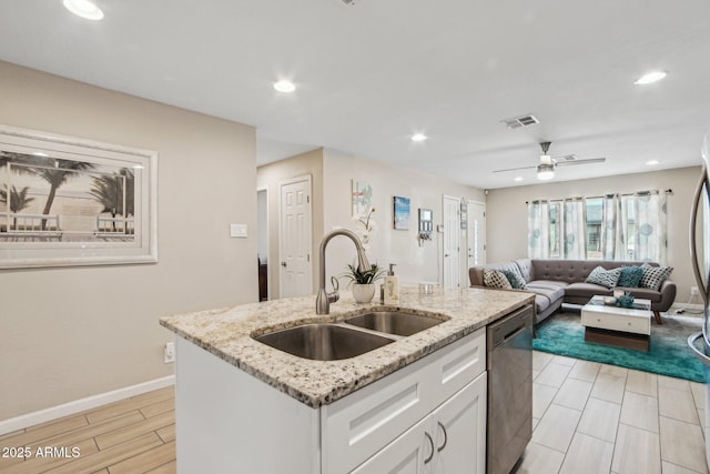 kitchen featuring white cabinetry, a center island with sink, a sink, visible vents, and dishwasher