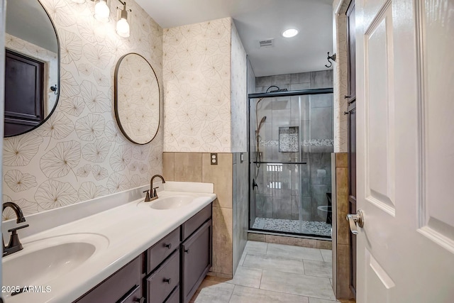 11936 W Alvarado Rd, Avondale, AZ 85392 - bathroom with a stall shower, tile walls, double vanity, and tile patterned floors