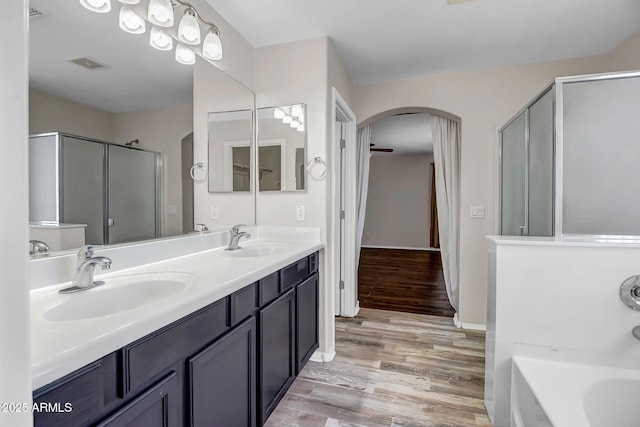11936 W Alvarado Rd, Avondale, AZ 85392 - bathroom with double vanity, wood finished floors, a shower stall, and a bath