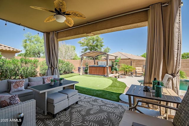 11936 W Alvarado Rd, Avondale, AZ 85392 - fenced backyard featuring an area to practice putting, a patio, outdoor lounge area, a hot tub, and ceiling fan
