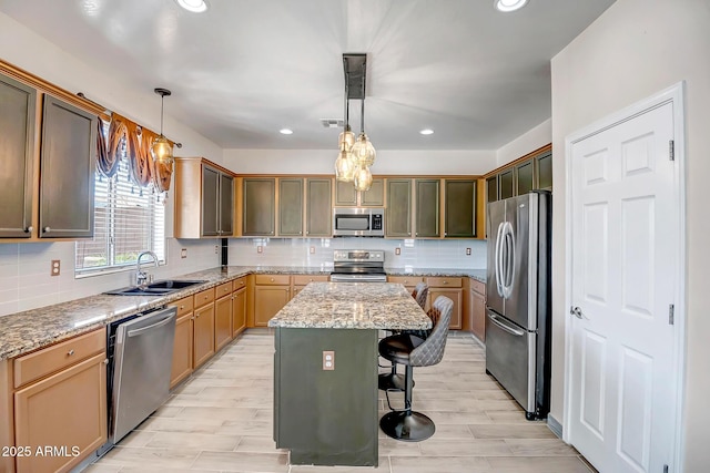 11936 W Alvarado Rd, Avondale, AZ 85392 - kitchen featuring appliances with stainless steel finishes, a center island, a breakfast bar area, decorative backsplash, and recessed lighting
