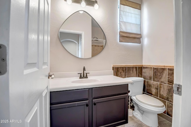 11936 W Alvarado Rd, Avondale, AZ 85392 - bathroom featuring tile walls, vanity, and wainscoting