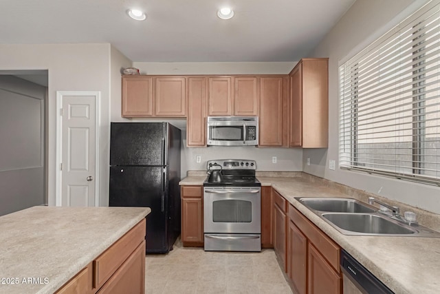 kitchen with appliances with stainless steel finishes, recessed lighting, light countertops, and a sink