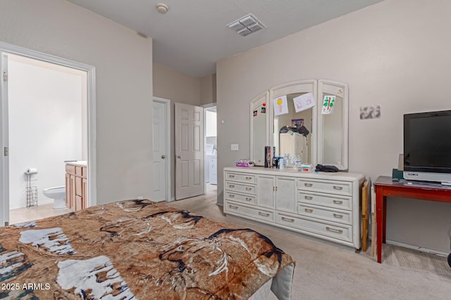 bedroom featuring ensuite bath, visible vents, and light colored carpet