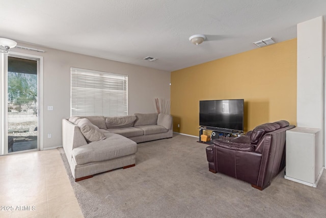 living room featuring visible vents, a textured ceiling, and baseboards