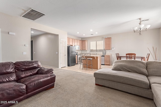 living room featuring a chandelier, recessed lighting, visible vents, and light colored carpet