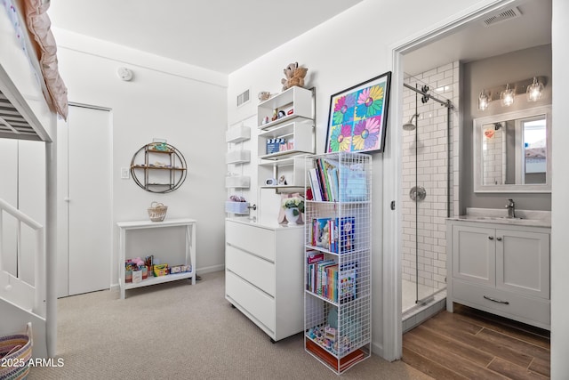 interior space featuring a shower with door, vanity, and hardwood / wood-style flooring