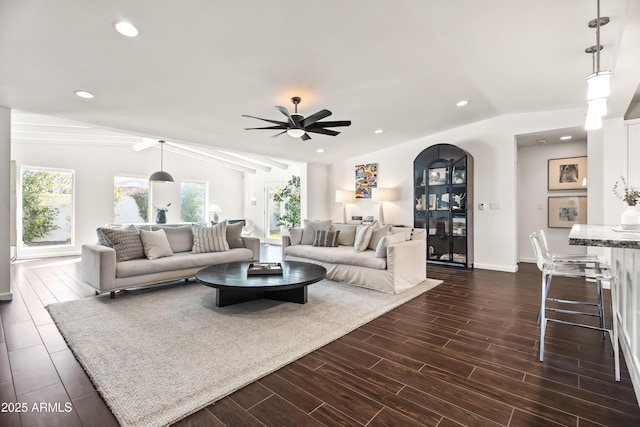 living room with dark wood-type flooring, vaulted ceiling, and a wealth of natural light