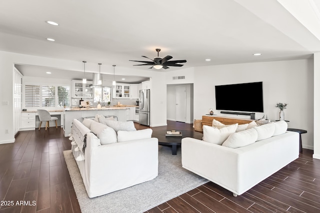 living room with ceiling fan and dark hardwood / wood-style flooring