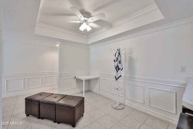 interior space featuring light tile patterned floors, a ceiling fan, and a raised ceiling