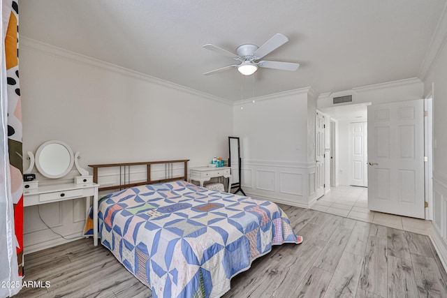 bedroom featuring visible vents, wood finished floors, and ornamental molding
