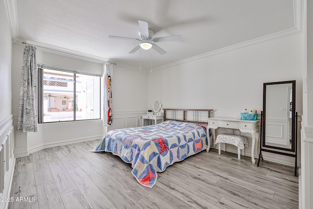 bedroom with ornamental molding, wood finished floors, and a ceiling fan