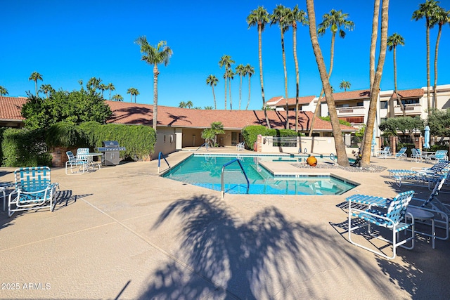 community pool with fence and a patio area