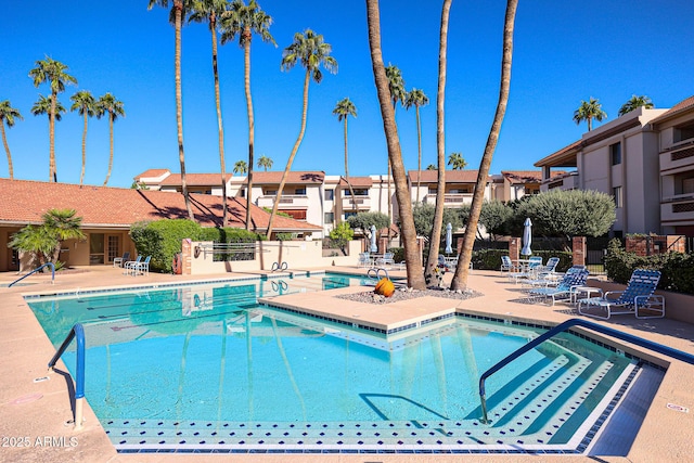 community pool featuring fence and a patio area