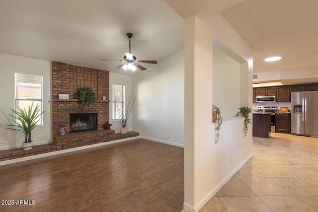 2925 E Dragoon Ave, Mesa, AZ 85204 - unfurnished living room featuring a ceiling fan, healthy amount of natural light, a brick fireplace, and light wood-type flooring