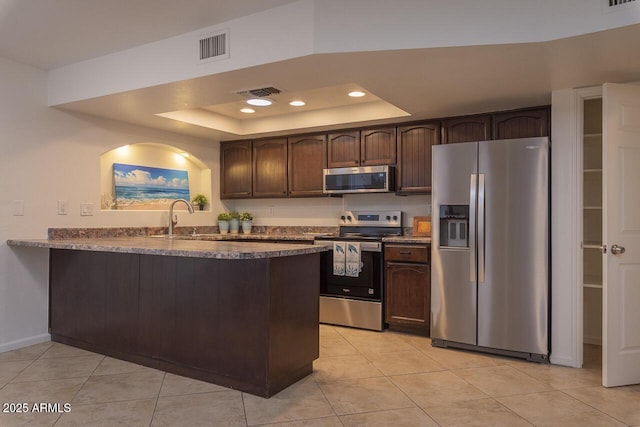 2925 E Dragoon Ave, Mesa, AZ 85204 - kitchen featuring stainless steel appliances, a raised ceiling, dark brown cabinets, light tile patterned flooring, and recessed lighting
