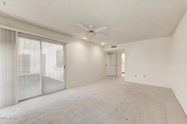 carpeted empty room with ceiling fan and a textured ceiling