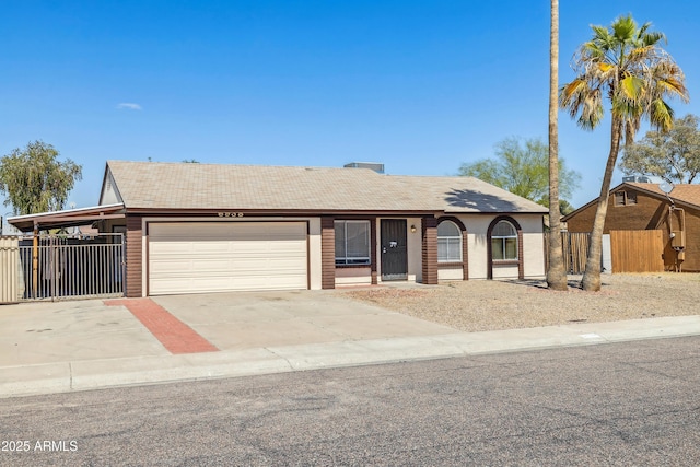 view of front of house with concrete driveway, an attached garage, and fence