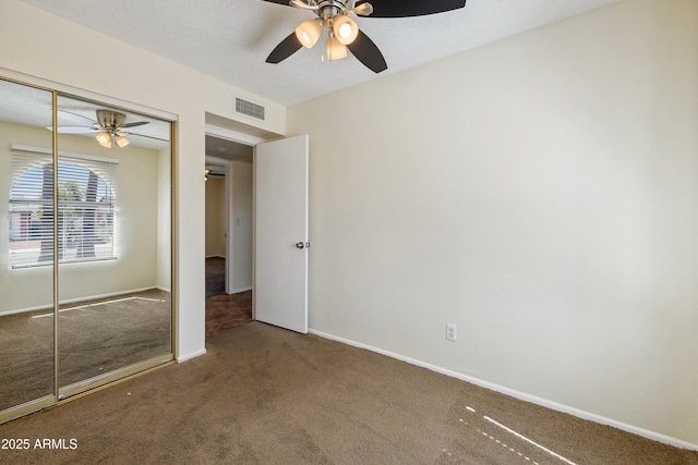 unfurnished bedroom featuring visible vents, baseboards, carpet floors, a closet, and a textured ceiling