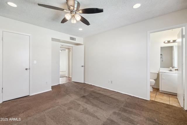 unfurnished bedroom featuring visible vents, light colored carpet, recessed lighting, a textured ceiling, and ensuite bath