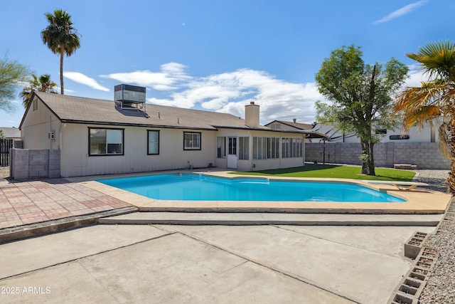 view of pool featuring a fenced in pool, fence, central AC, a sunroom, and a patio area