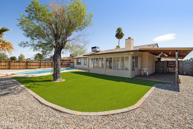 rear view of house featuring a patio, a fenced backyard, cooling unit, a fenced in pool, and a chimney